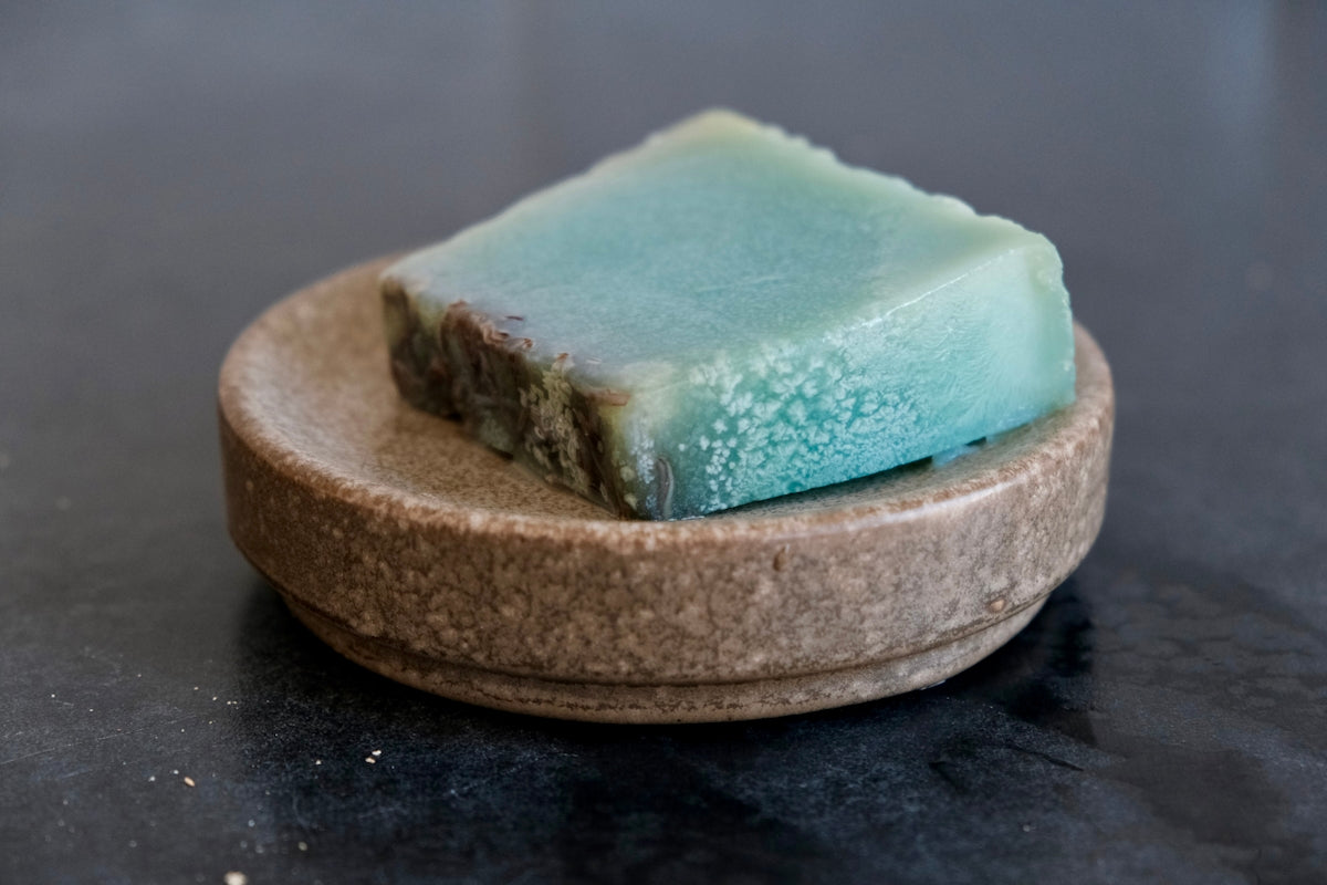 a piece of soap sitting on top of a wooden plate